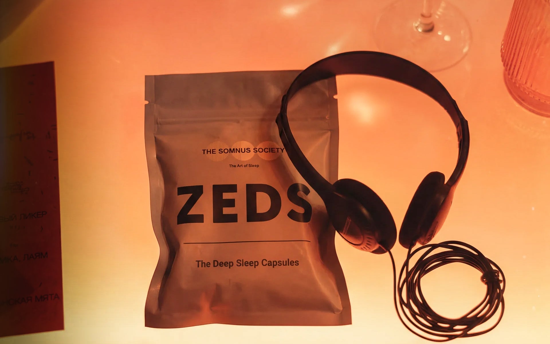 A ZEDS pouch and headphones on a warm-lit lounge table
