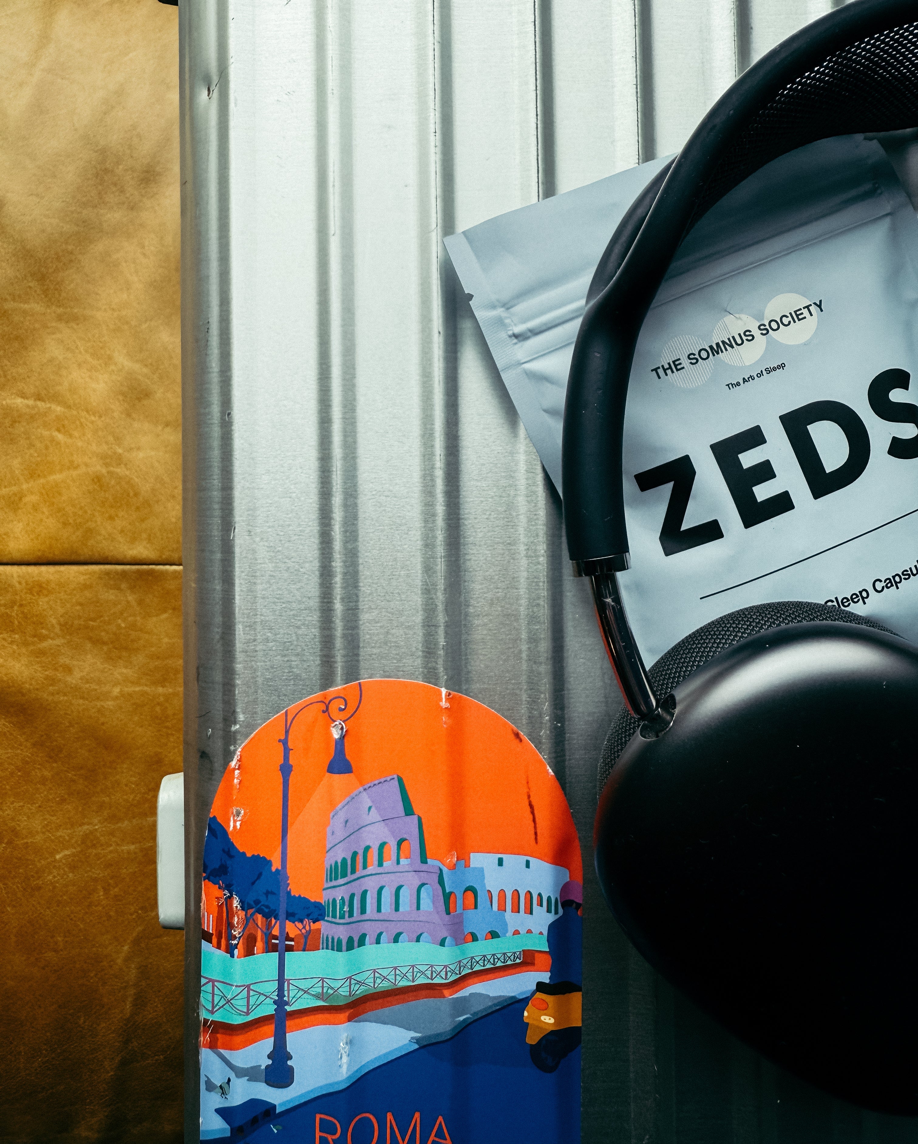 Headphones resting on a leather travel case